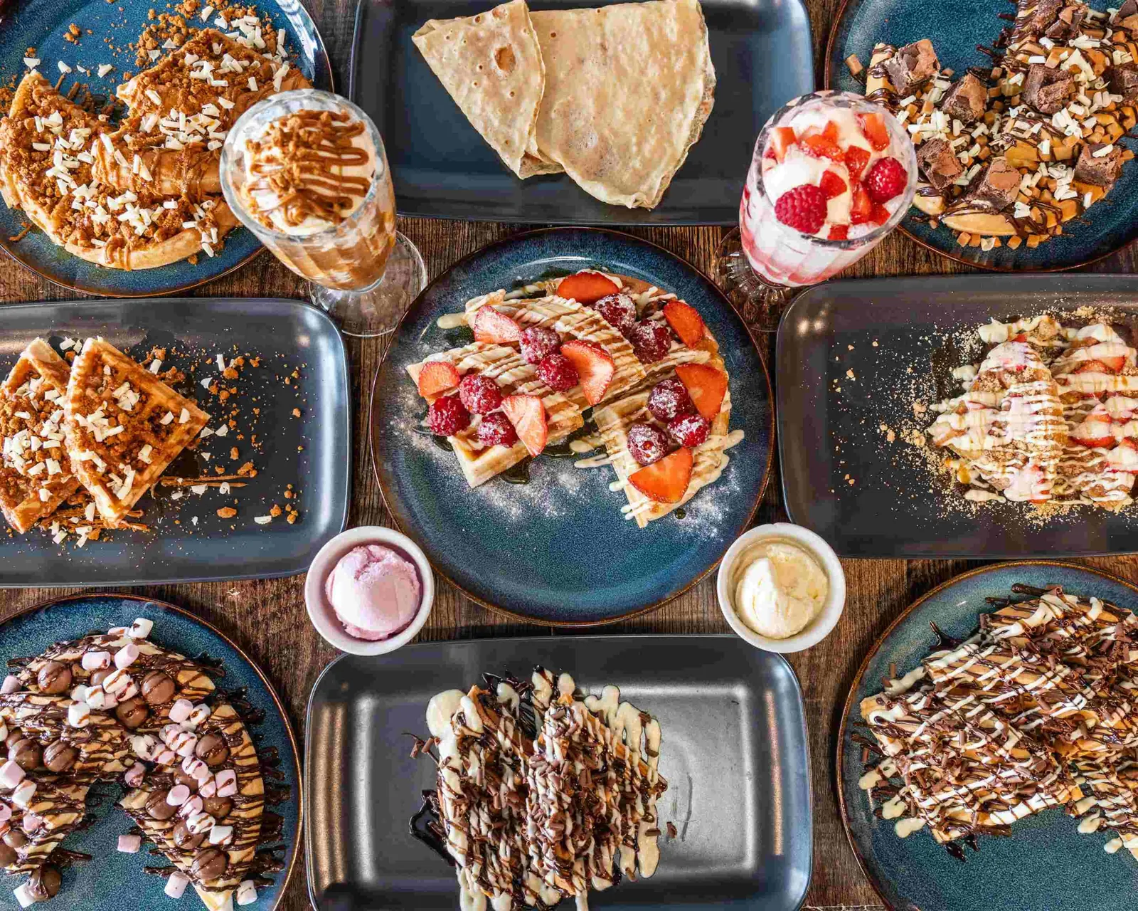 A table spread with waffles, crepes, sundaes and shakes